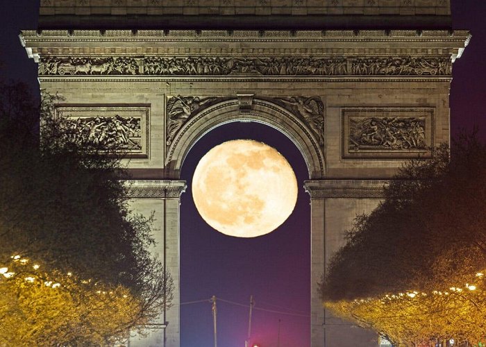 Arc de Triomphe Paris's Arc de Triomphe Perfectly Frames a Glowing Full Moon in a ... photo